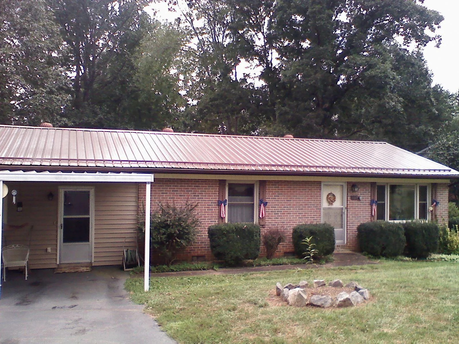 Bronze metal roof and carport on a brick ranch home — Roof Repair work by our crew in Tacoma